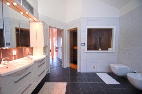 a bathroom with two sinks and a toilet at Penthouse Bruckberg by Four Seasons Apartments in Zell am See