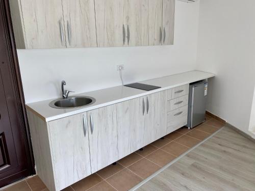a kitchen counter with a sink and a refrigerator at UpART House in Petrovac na Moru
