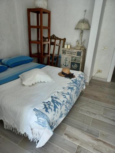 um quarto com uma cama com um chapéu em Magi - Violetta em Ponza