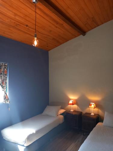 twee bedden in een kamer met twee lampen erop bij O Ninho do Rei in Vila de Rei