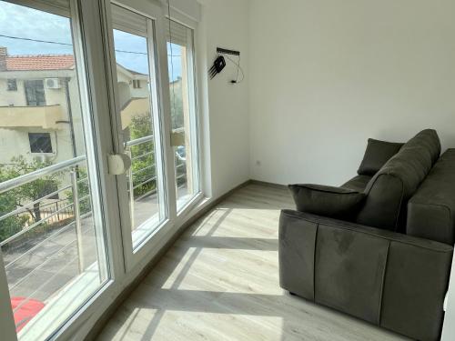 ein Wohnzimmer mit einem Sofa und einem großen Fenster in der Unterkunft UpART House in Petrovac na Moru