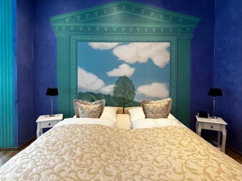 a bedroom with a large bed with a green headboard at PARK VILLA zentral am Mittelrhein in Boppard