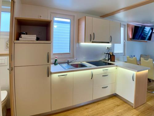 - une cuisine avec des placards blancs et un évier dans l'établissement BellaVista HouseBoat Apartment Portorose, à Portorož