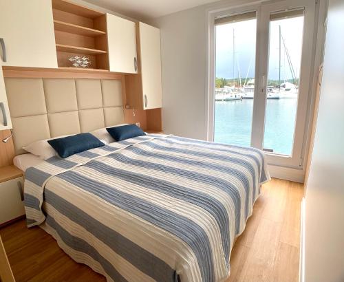 - une chambre avec un lit et une vue sur l'eau dans l'établissement BellaVista HouseBoat Apartment Portorose, à Portorož