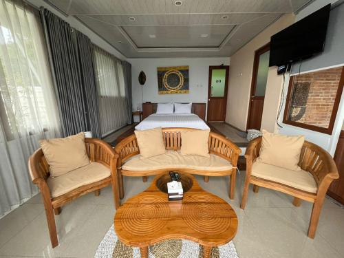 Campaka的住宿－De Pointé Resort & Resto，一间卧室配有一张床、两把椅子和一张桌子