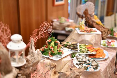 a table with several plates of food on it at Hotel Ca' D'Oro Tre Stelle Superior Adults only in Bibione