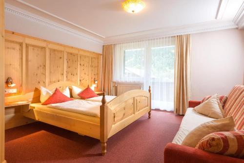 a bedroom with a bed and a desk and a couch at Landhaus Angelika in Gaschurn