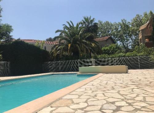 une piscine devant une maison dans l'établissement T2 refait à neuf, au calme, piscine, parking privé, à La Seyne-sur-Mer