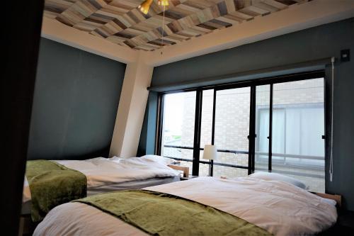 a bedroom with two beds and a large window at Condo within Tokyo DisneyResort 10 people can stay in Tokyo