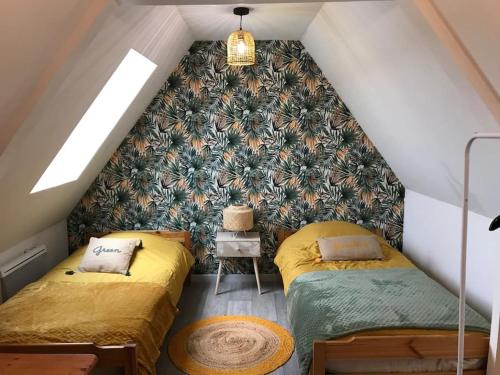 a attic room with two beds and a wall at Maison avec spa - Côte d'Opale in Lottinghen