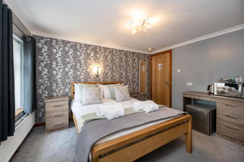 a bedroom with a bed and a desk and a bed sidx sidx sidx at The New Lodge in Pontardawe