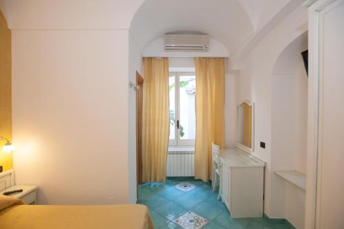 Habitación pequeña con cama y ventana en Hotel Villa Sirena - Thermae & SPA, en Isquia