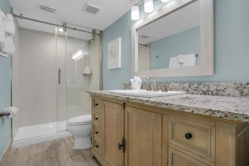 a bathroom with a sink and a toilet and a mirror at Beach House 603D- Rest Ashore in Destin