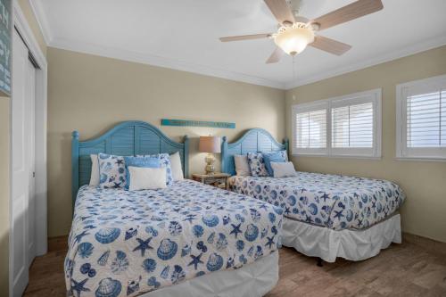 a bedroom with two beds and a ceiling fan at Beach House 603D- Rest Ashore in Destin