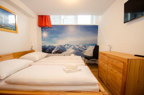 Residence Alpin - Studio-10 B by Four Seasons Apartments في كابرون: سريرين في غرفة مع صورة على الحائط