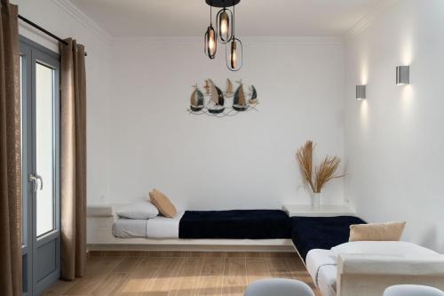 a white living room with a bed and a window at Bliss Holidays Spot in Fira