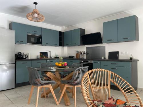 a kitchen with blue cabinets and a table and chairs at Appartement lumineux rénové à neuf in Saint-Pierre