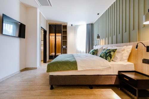 a bedroom with a large bed and a television at Amazonia Hotel in Timişoara