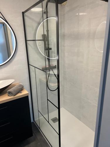 een douche met een glazen deur in de badkamer bij « Le Andrea » in Cavalaire-sur-Mer