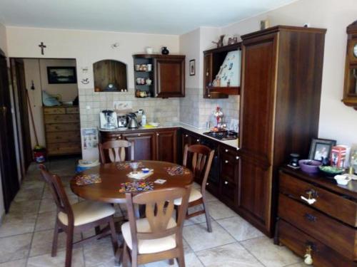 cocina con mesa de madera, mesa y sillas en Garden Apartment, en Oborniki Śląskie