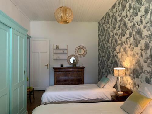 1 dormitorio con 2 camas y un mural en la pared en La Maison des Jardins en Naujac-sur-Mer
