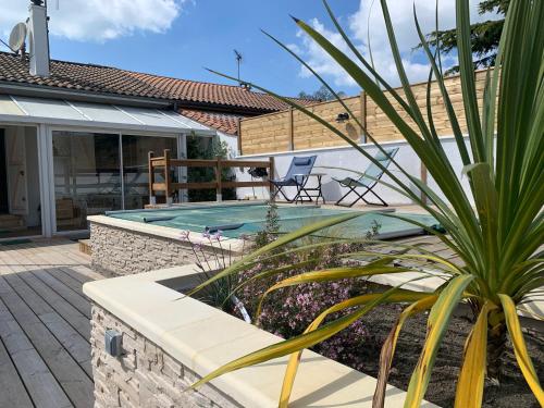 une piscine dans une cour avec une maison dans l'établissement La Maison des Jardins, à Naujac-sur-Mer