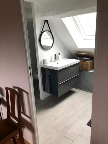 a bathroom with a sink and a skylight at Grande chambre avec salle de bain et WC privés in Pontgouin
