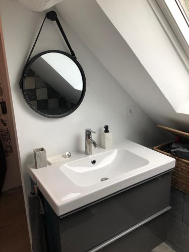 une salle de bain avec un lavabo blanc et un miroir dans l'établissement Grande chambre avec salle de bain et WC privés, à Pontgouin