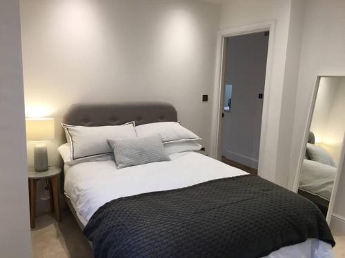 a bedroom with a large bed and a mirror at No.1 The Old Printworks, Winchester in Winchester