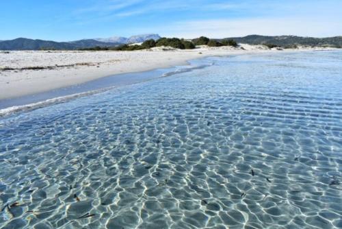 a beach with ripples in the water at ARC BLEu in Siniscola
