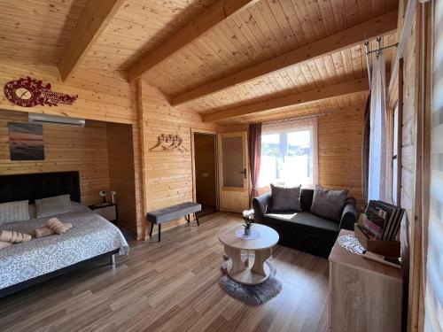 ein Wohnzimmer mit einem Bett und einem Sofa in der Unterkunft Atpūtas mājiņas Kolkā- Madaras un Rota in Kolka