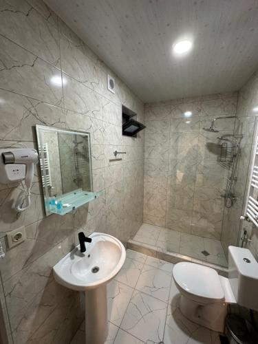 La salle de bains est pourvue d'un lavabo, d'une douche et de toilettes. dans l'établissement Old district, à Kazbegi
