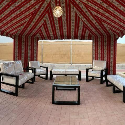 a group of benches and tables in a tent at afnan farm in Al Ḩamrānīyah