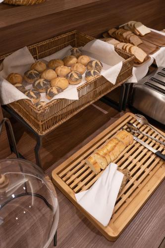 a table topped with baskets of bread and pastries at Boutique Hotel Touring in Verona