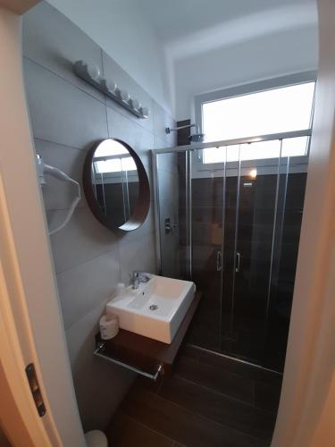 a bathroom with a sink and a shower and a mirror at Hotel Royal Plaza in Rimini
