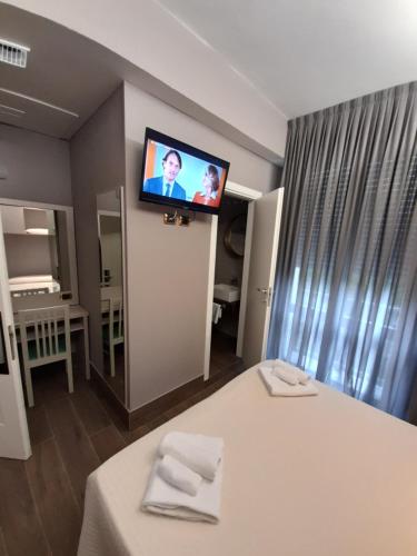 a room with a bed with a tv on the wall at Hotel Royal Plaza in Rimini