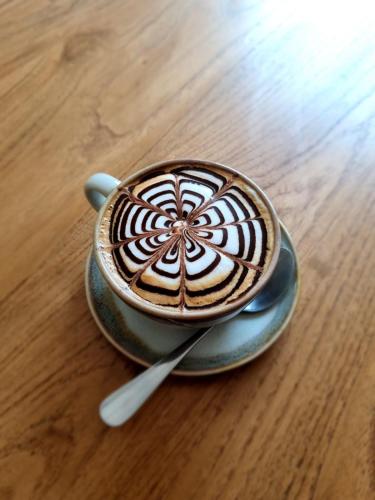 a cup of coffee sitting on a table at The Peaberry Boutique Hotel in Chiang Mai