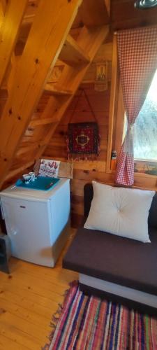 a room with a couch and a table in a attic at Seoski Turizam Feniks - apartman Ostrog in Kosjerić