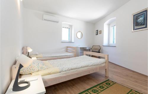 - une petite chambre avec 2 lits et un bureau dans l'établissement Amazing Home In Opuzen With Kitchen, à Opuzen