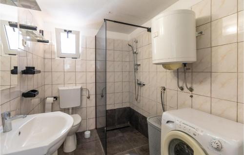 La salle de bains est pourvue d'un lavabo et d'un lave-linge. dans l'établissement Amazing Home In Opuzen With Kitchen, à Opuzen