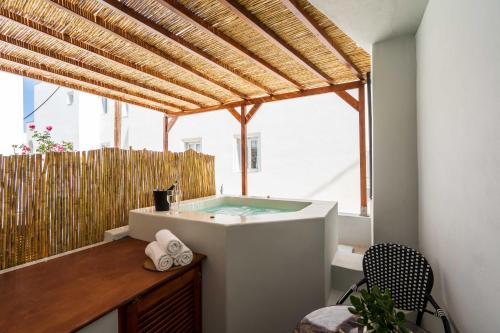 a bath tub in a room with a large window at Elixir Del Mar on the Beach in Kamari