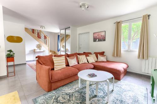a living room with a couch and a table at Square-bnb - La Maison Pastèque à 8min de Disney in Montévrain