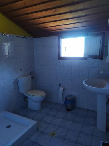 a bathroom with a toilet and a sink at Double studio room in Mylopotamos in Tsagarada