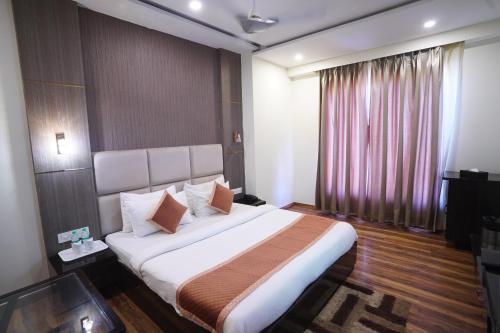 Un dormitorio con una cama grande y una ventana en Hotel Idhayan Palace, en Vrindāvan