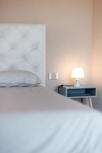 a bedroom with a bed and a nightstand with a lamp at Ca' del magu in San Michele Mondovì