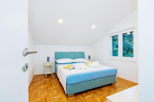 a bedroom with a blue bed and a window at House Duje in Plano