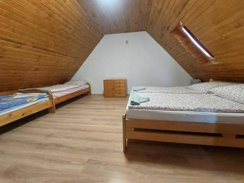 two beds in a room with a attic at Orbán nyaralóház in Kővágóörs