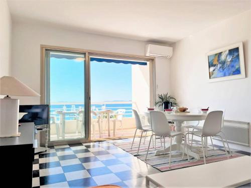 - un salon avec une table et des chaises et une vue sur l'océan dans l'établissement Appartement 2 pièces, 4 couchages, climatisé avec Wi-Fi et garage - Le Lavandou - FR-1-251-293, au Lavandou