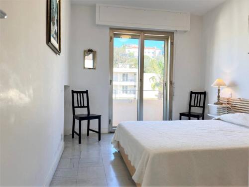 une chambre avec un lit et deux chaises et une fenêtre dans l'établissement Appartement 2 pièces, 4 couchages, climatisé avec Wi-Fi et garage - Le Lavandou - FR-1-251-293, au Lavandou