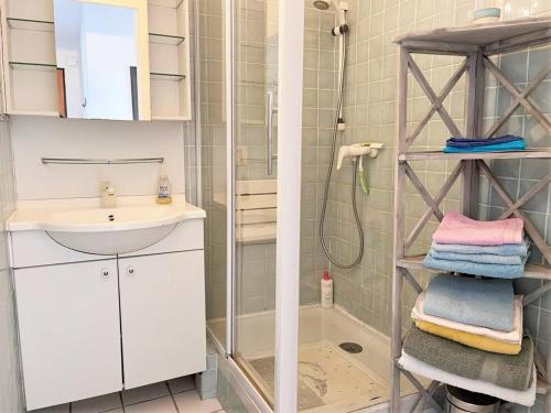 La salle de bains est pourvue d'un lavabo, d'une douche et de serviettes. dans l'établissement Appartement 2 pièces, 4 couchages, climatisé avec Wi-Fi et garage - Le Lavandou - FR-1-251-293, au Lavandou